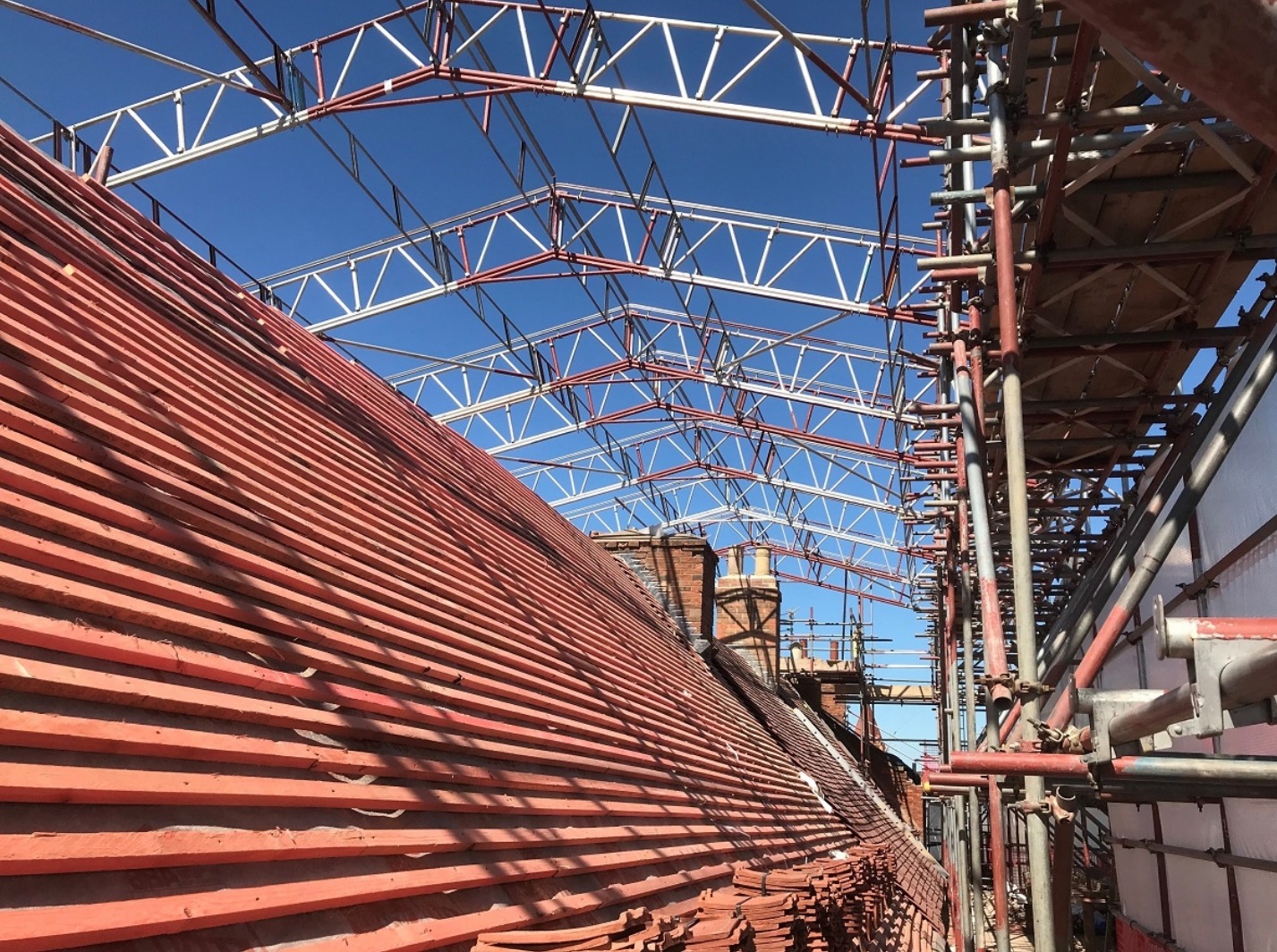 Temporary roof structure above a tiled roof during works Temporary roof structure above a tiled roof during works
