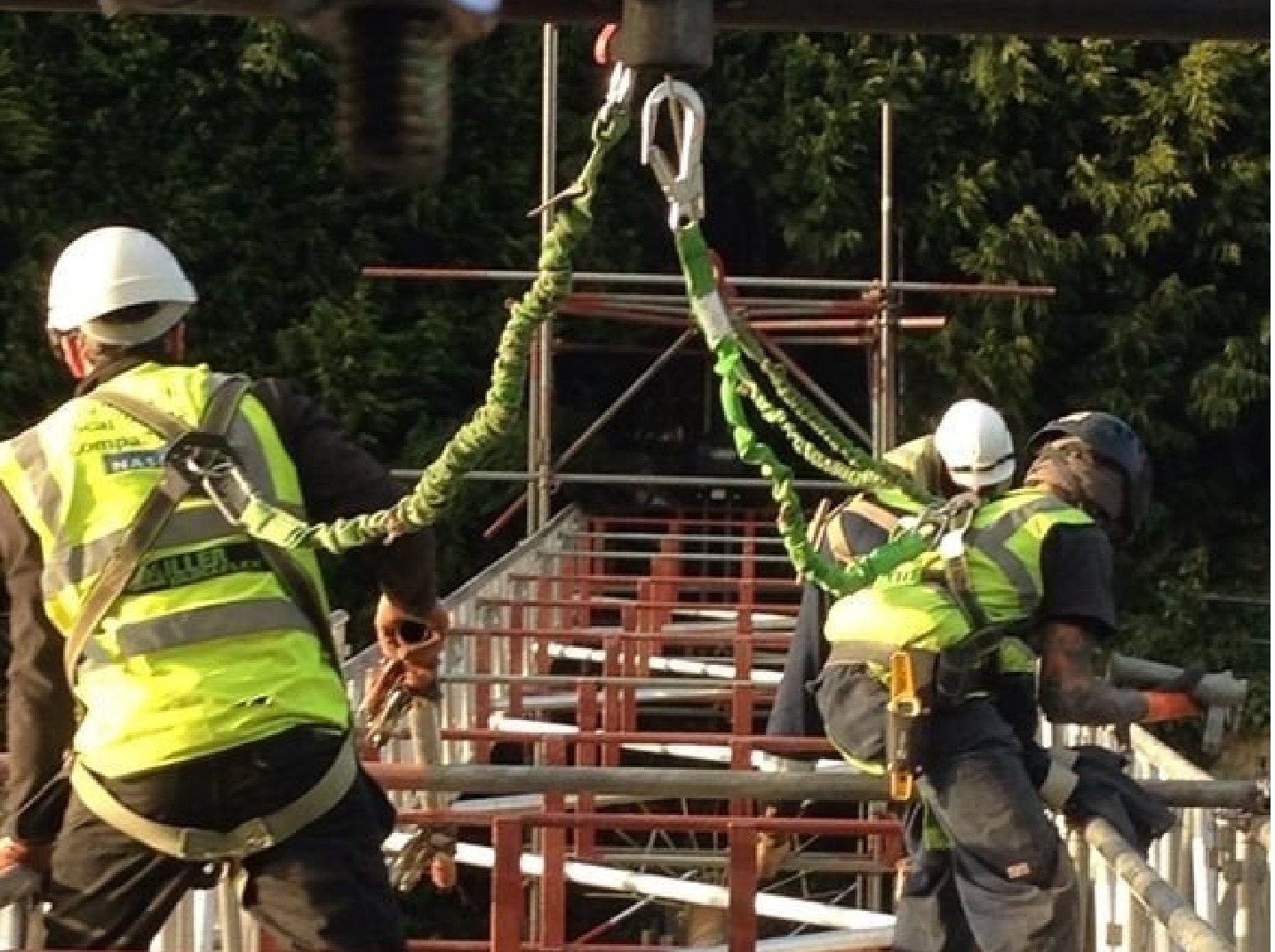 Scaffolding operatives working safely on site with harnesses and PPE Scaffolding operatives working safely on site with harnesses and PPE