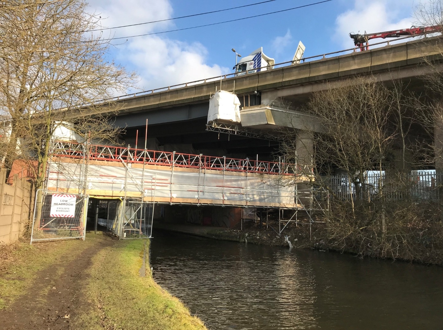 Temporary bridge scaffold over a canal for utilities access Temporary bridge scaffold over a canal for utilities access